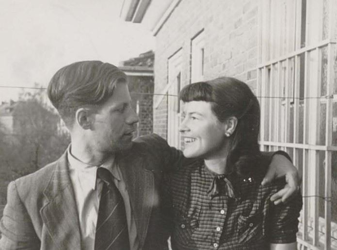 Helmut and Hannelore Schmidt looking at each other, he has his arm around her while she smiles.